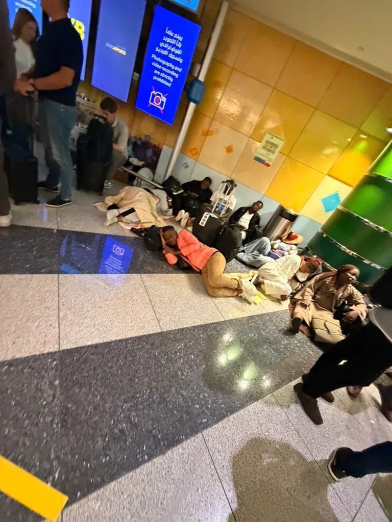 在巨大的机场大厅里,一排排旅客靠着背包、行李、墙壁休息,看起来真有点像临时的难民营··· 在巨大的机场大厅里,一排排旅客靠着背包、行李、墙壁休息,看起来真有点像临时的难民营···